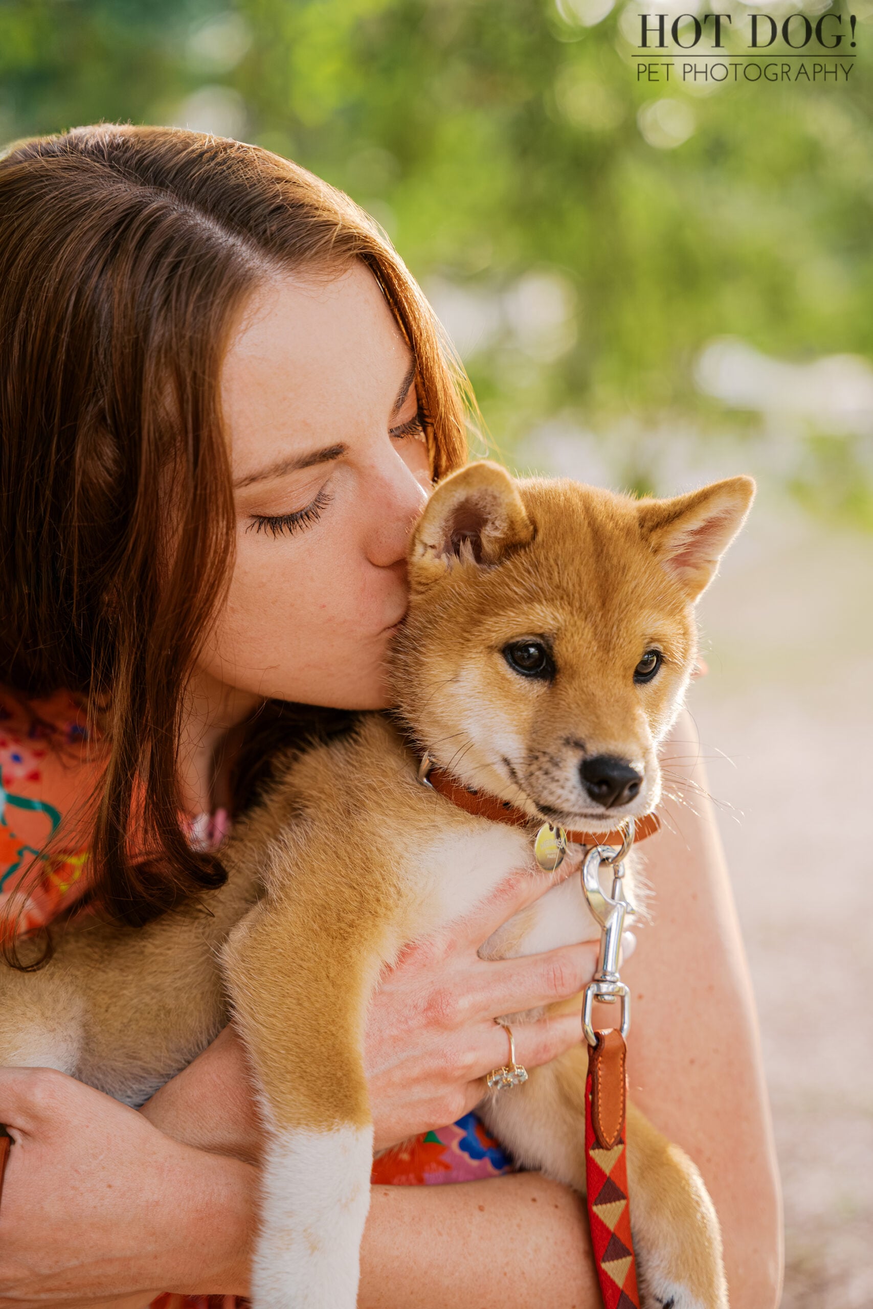 Alyssa cuddling and kissing 12-week-old Shiba Inu puppy Auro during his Orlando puppy photography session.