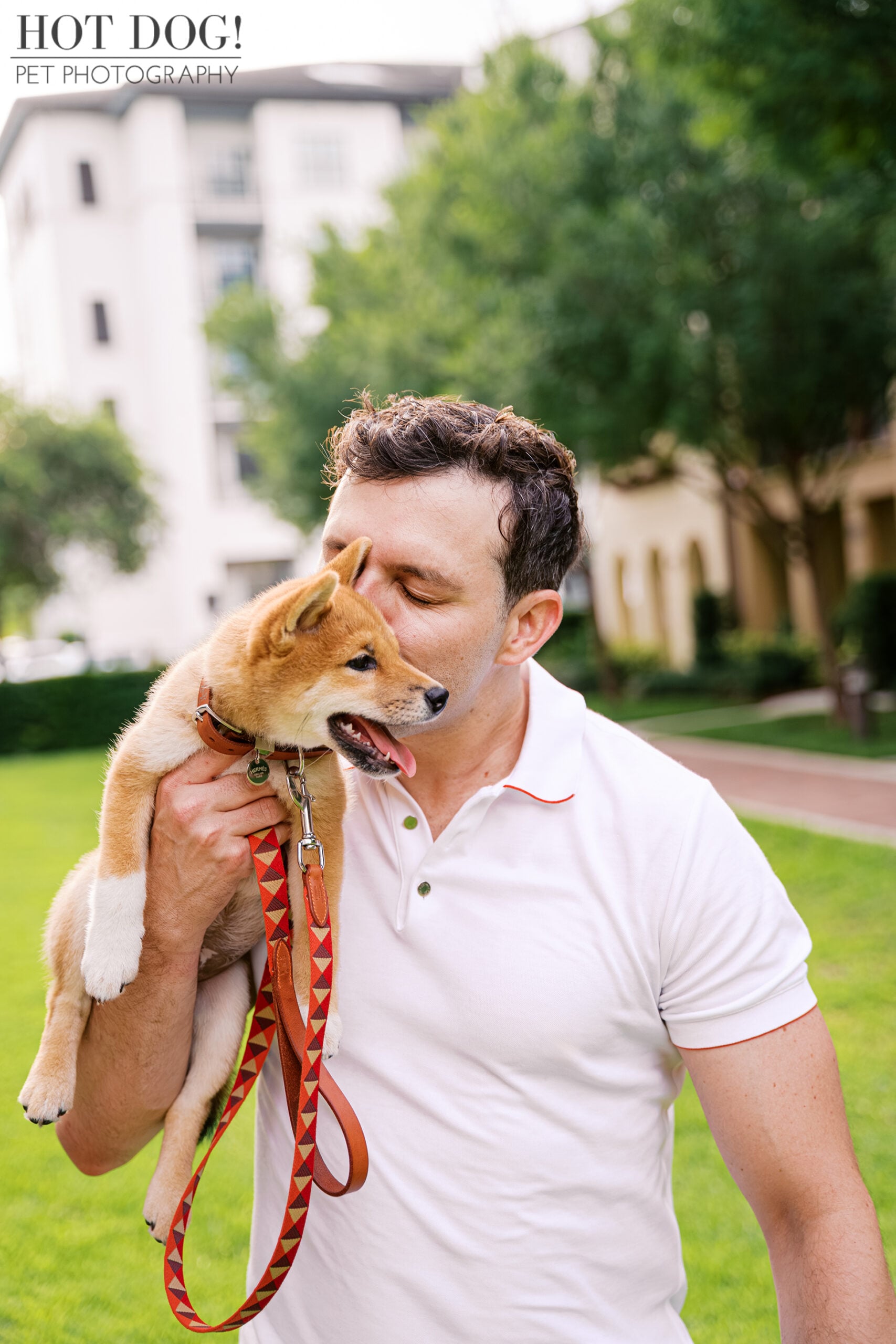 Mike kisses Shiba Inu puppy Auro while holding him during their pet photography session in Baldwin Park, Orlando.