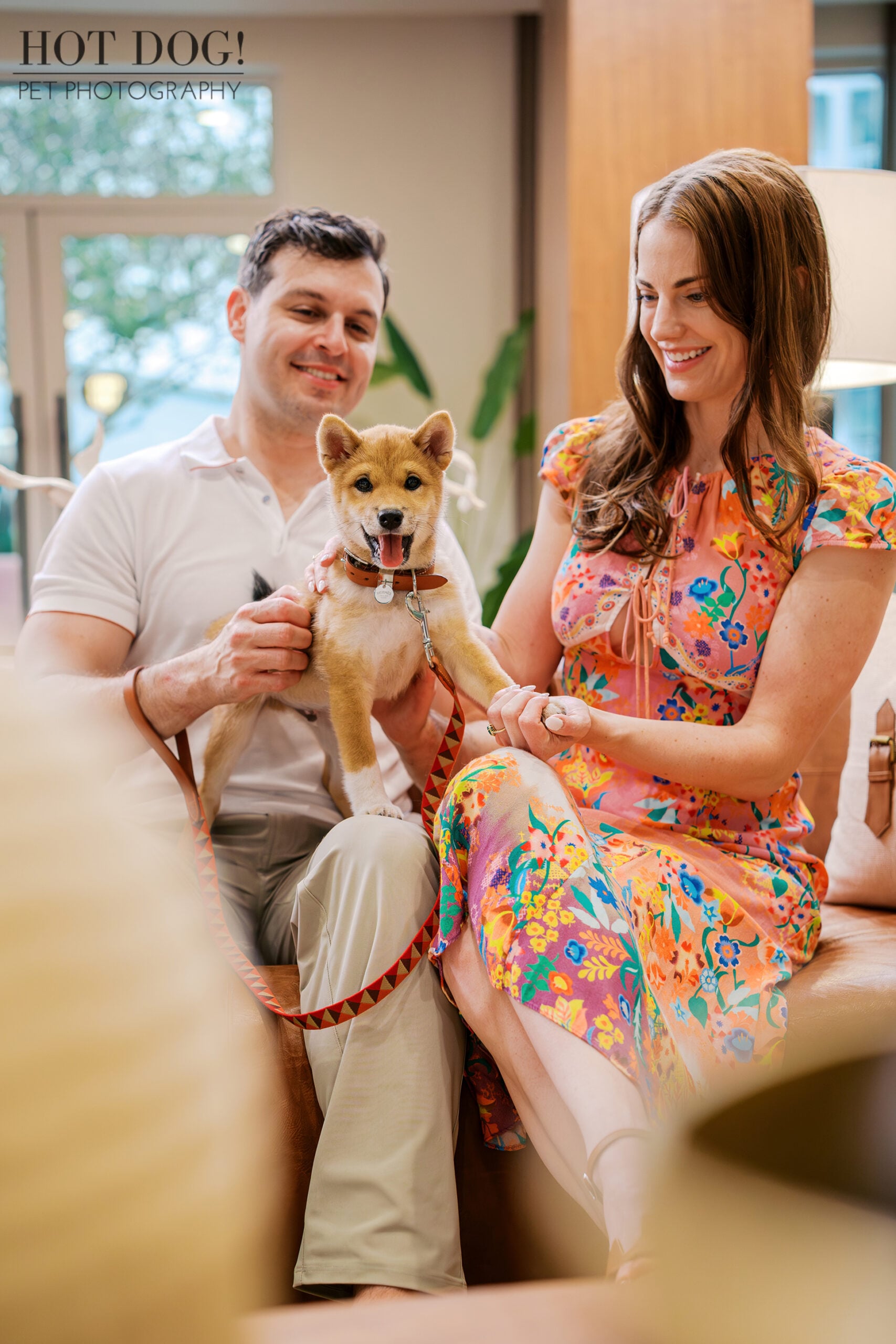 Alyssa and Mike cuddle their smiling Shiba Inu puppy Auro during an indoor family pet portrait in Baldwin Park.