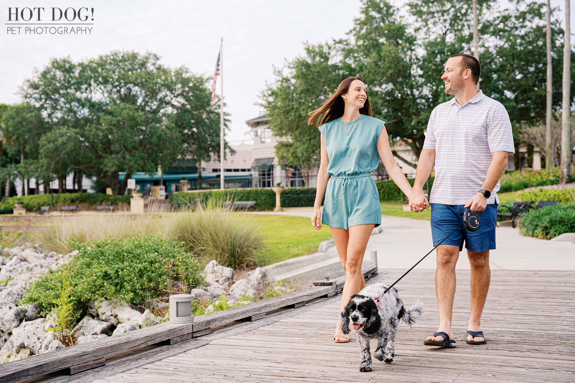 Couple walking with their senior cocker spaniel Ella along the boardwalk at Harbor Park in Baldwin Park during an outdoor pet photography session.