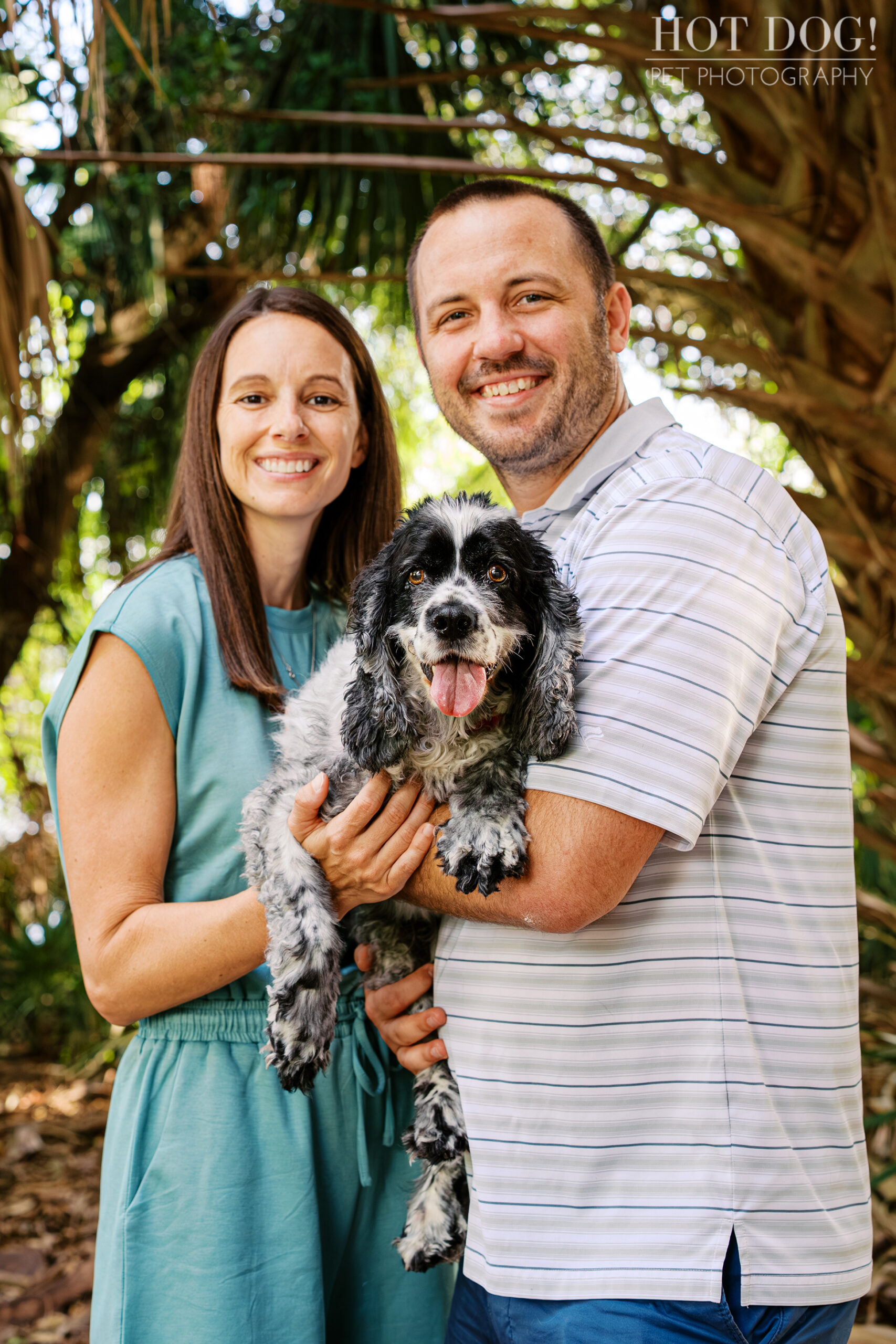 Tiffany and Rob holding their senior cocker spaniel Ella during a family pet photography session at Harbor Park in Baldwin Park.