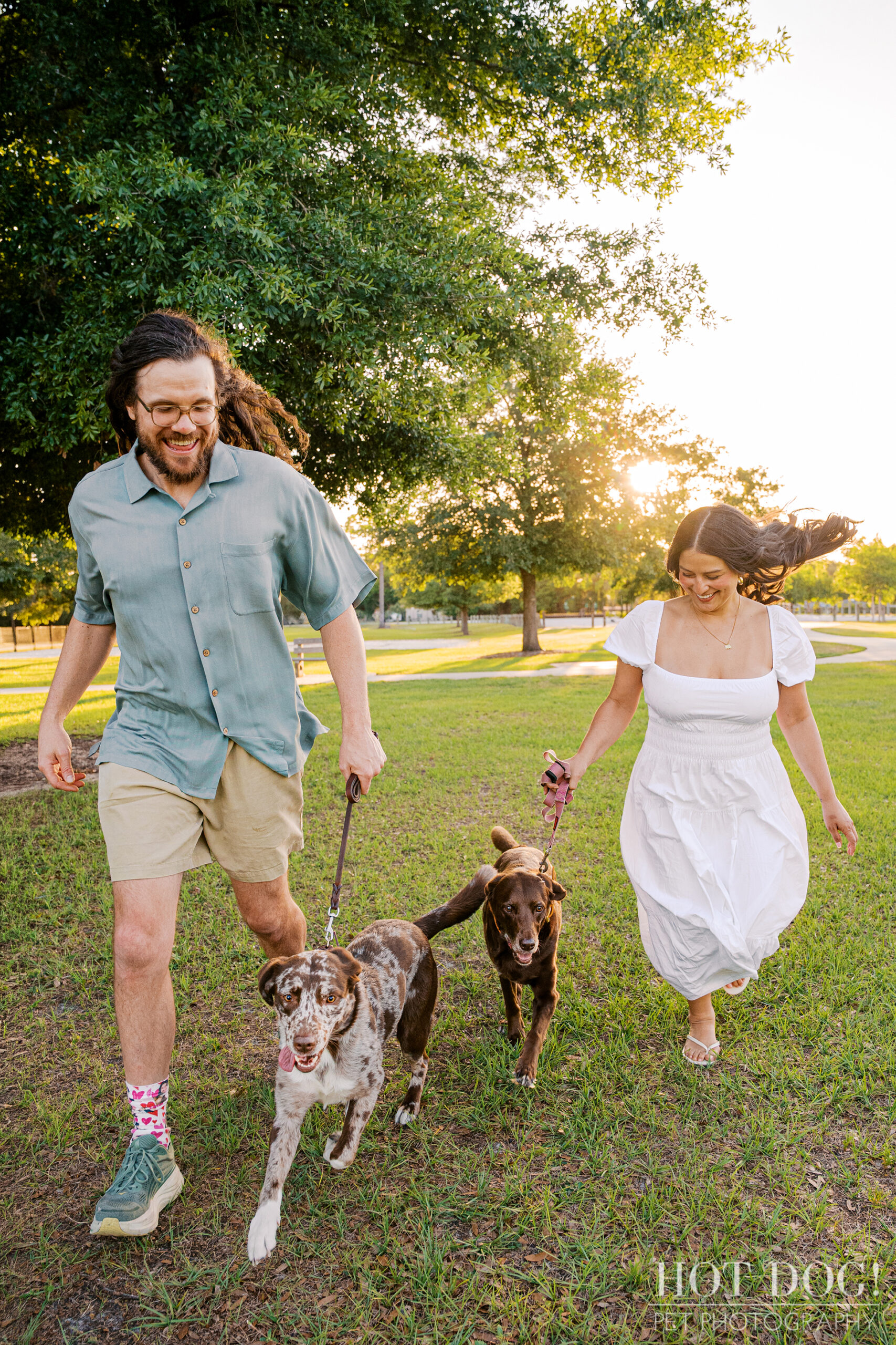 Anne and Jared walk with Gemma and Ellie through Lake Druid Park during a fun-filled family dog photography session in Orlando.