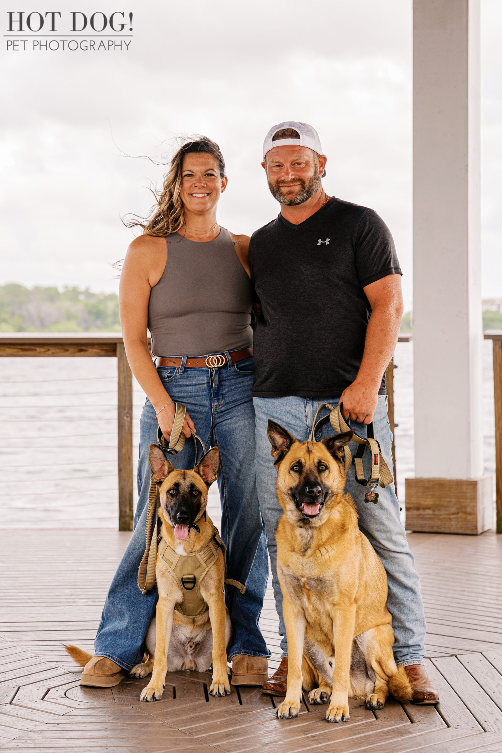Krystle and Scott standing with Maverick and Goose on a lakeside dock at Harbor Park in Baldwin Park during a pet photography session.