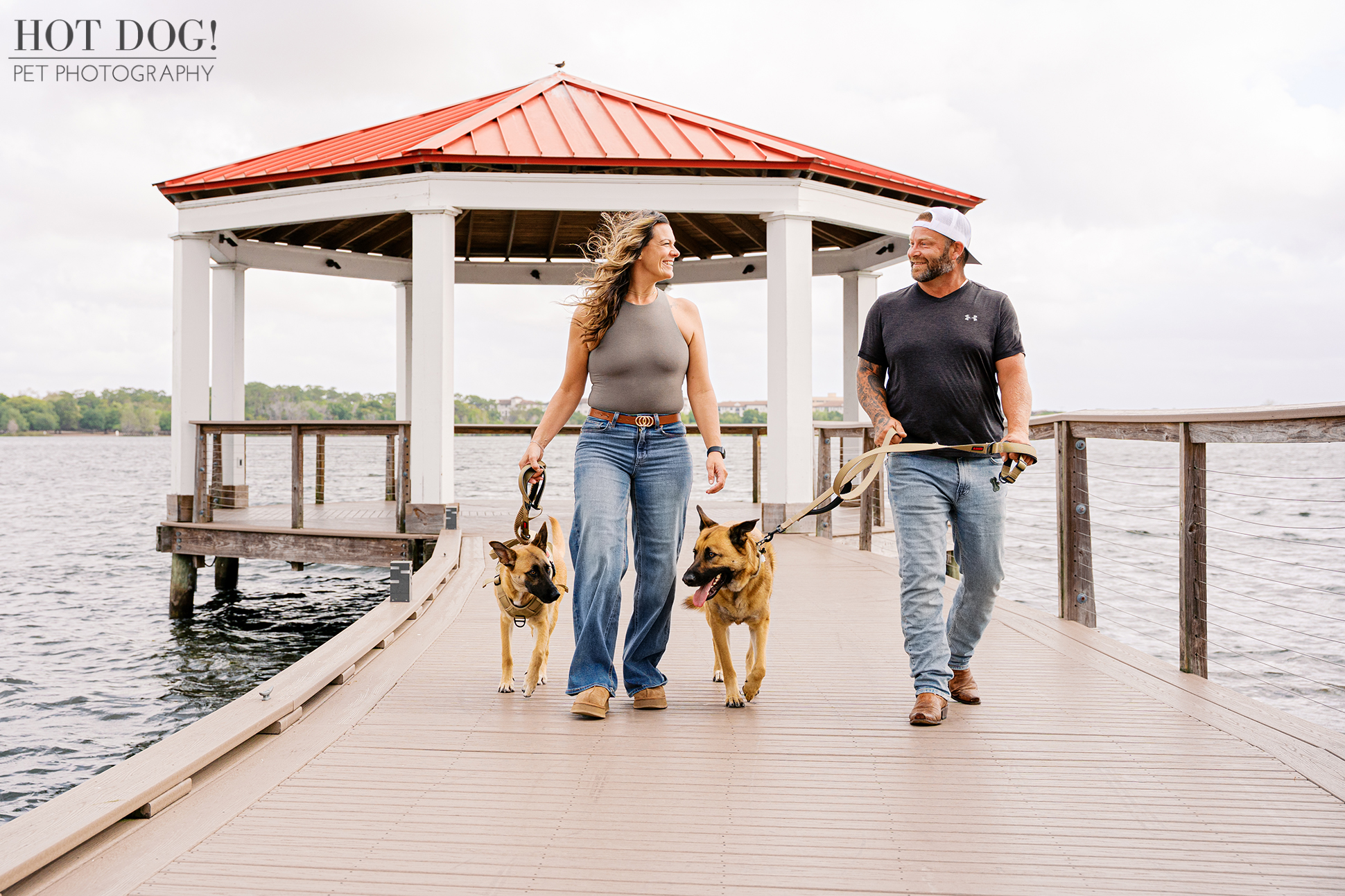 Krystle and Scott walking Maverick and Goose along a wooden dock at Harbor Park in Baldwin Park on a breezy morning.