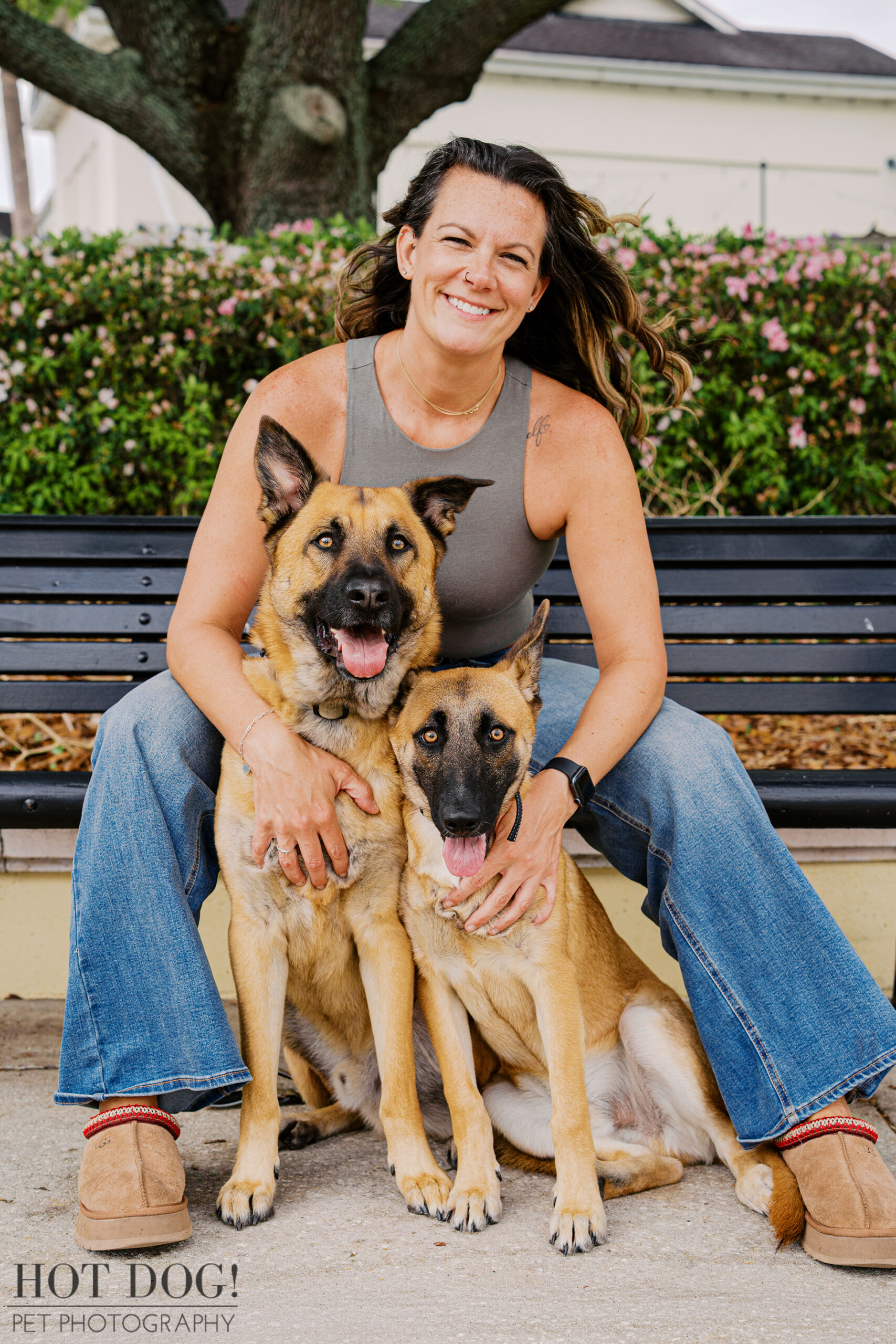 Krystle sitting with Maverick and Goose on a bench, both dogs close and relaxed, during an outdoor pet photography session in Baldwin Park.