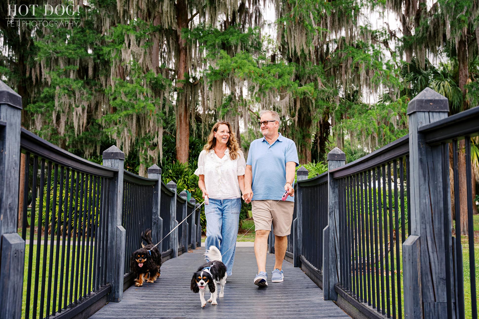 Tonia and James smiling together while walking Jazmyn and Jerzee across a bridge during their Florida vacation pet photography session.