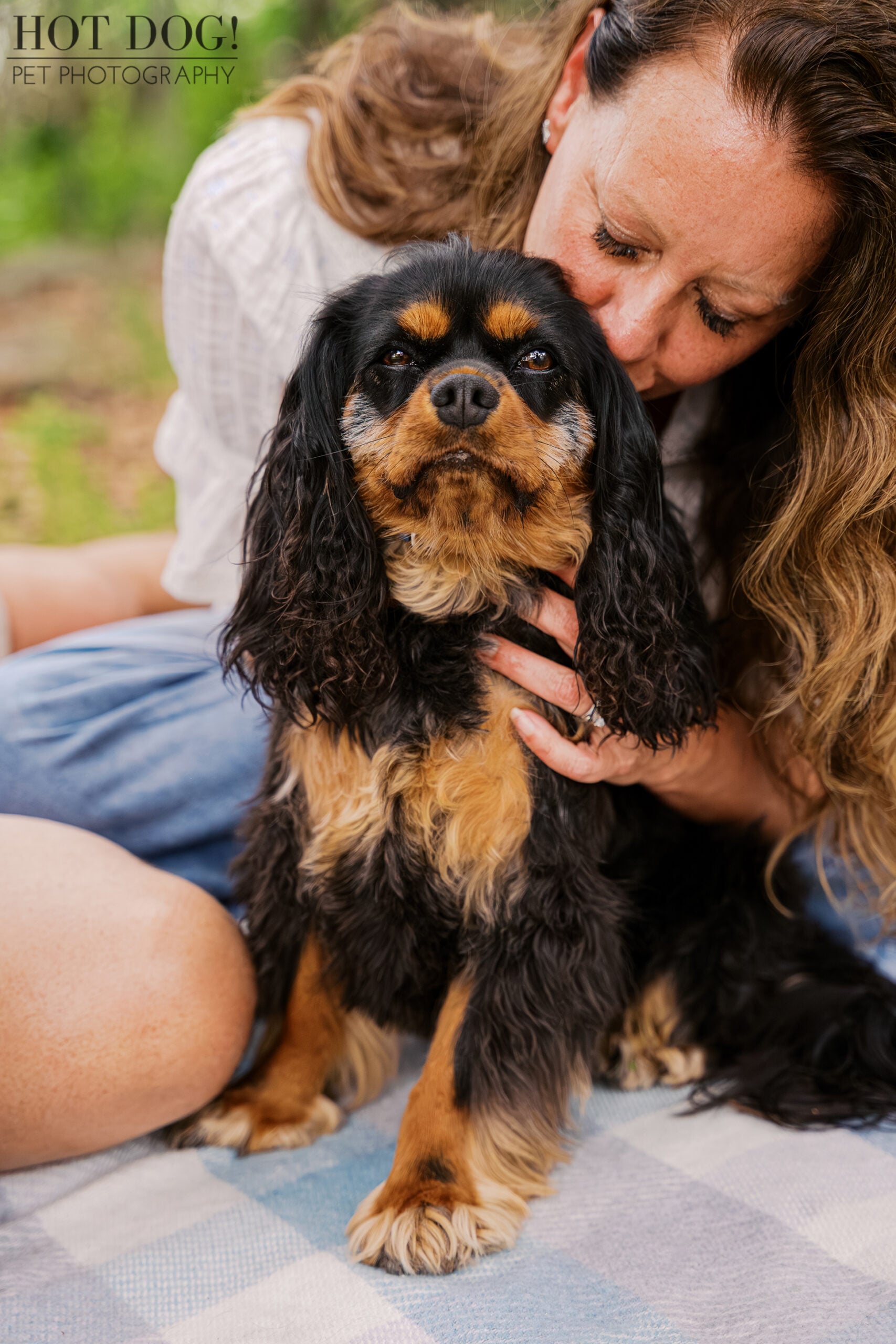 Tonia cuddling black and tan Cavalier King Charles Spaniel Jazmyn during their Florida vacation pet photography session.