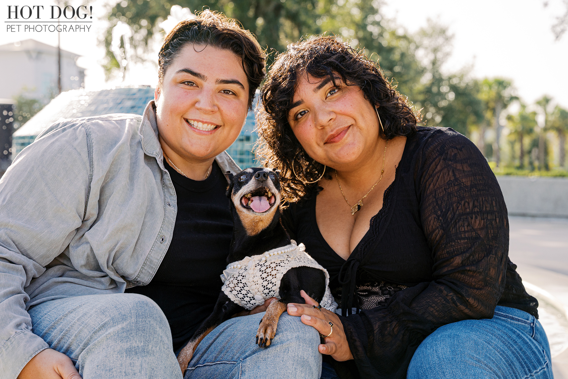 Gabriela and Taylor posing with Kiki in a white lace dress by the fountain during their Cherished Companion Session.