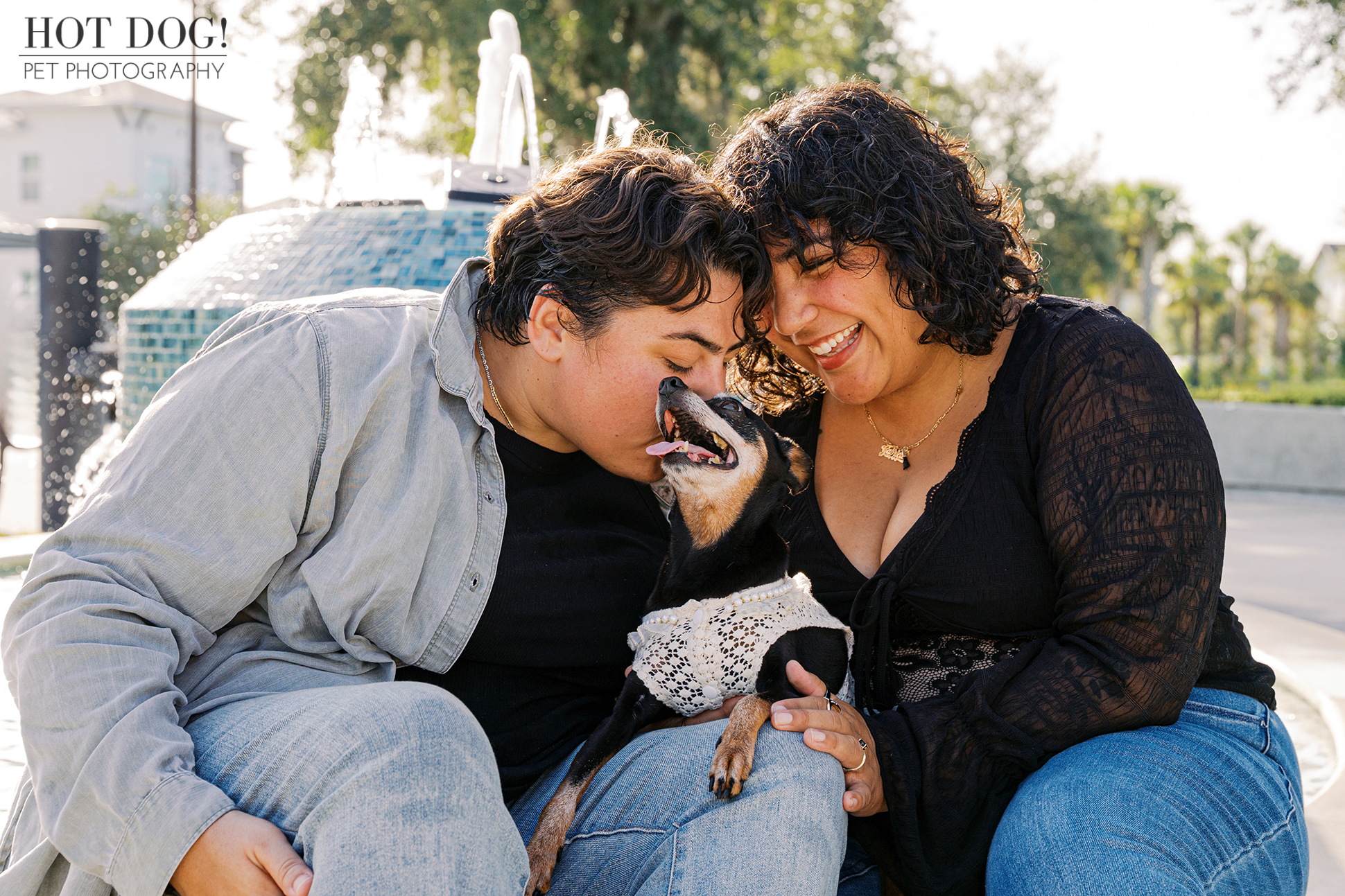 Candid moment of Taylor kissing Kiki while Gabriela smiles, sitting together by the fountain.