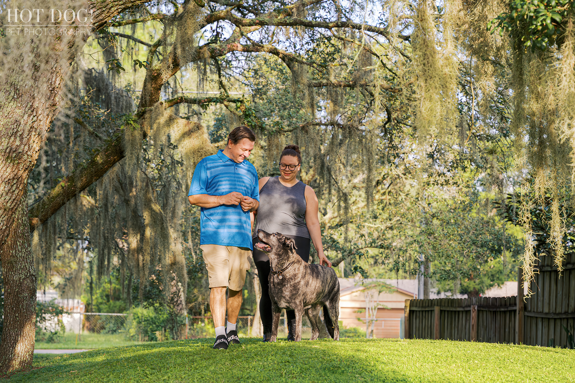 Lukasz and Natasha strolling through their yard with Leah, who looks up at them with love.