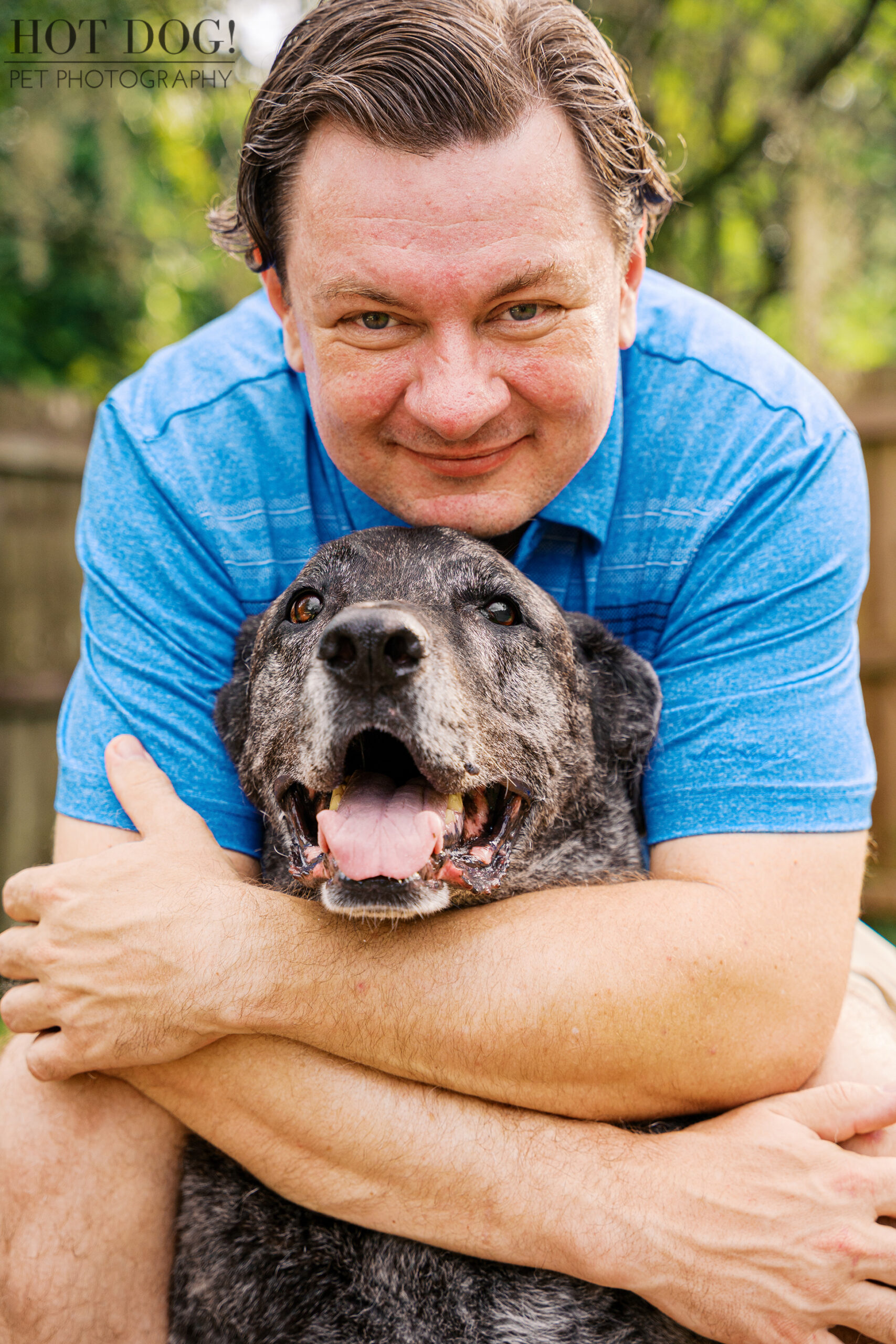 Lukasz hugging Leah, his 11-year-old brindle Mastiff/Shepherd mix, during their Signature Pet Session with Hot Dog! Pet Photography.