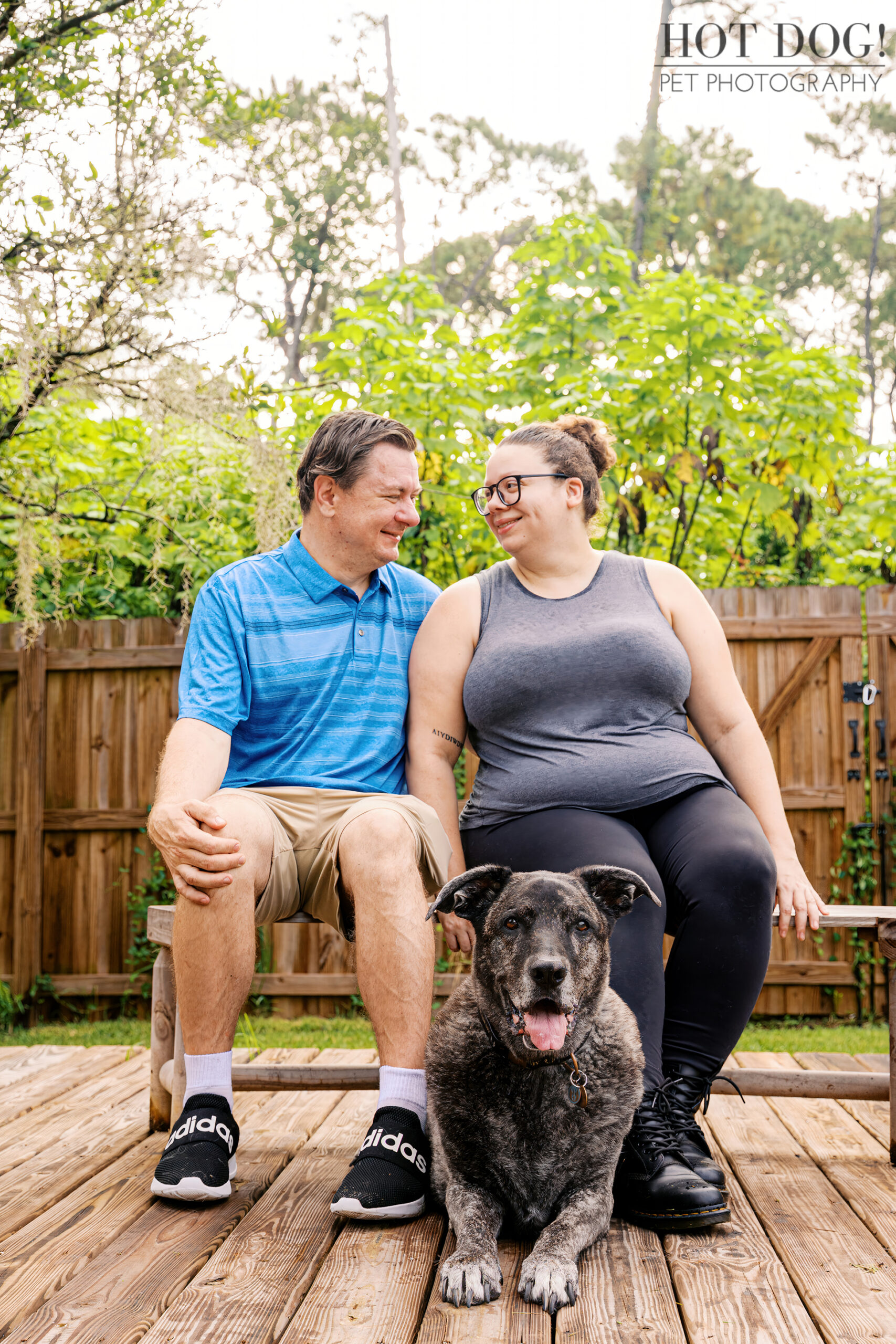 Leah sitting at her family’s feet on the deck, with Lukasz and Natasha smiling at each other behind her.