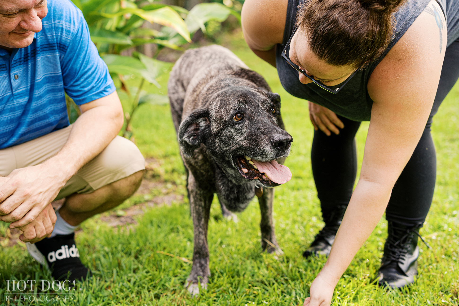 Leah looking up with a happy expression as Natasha bends down to interact with her, while Lukasz smiles nearby.