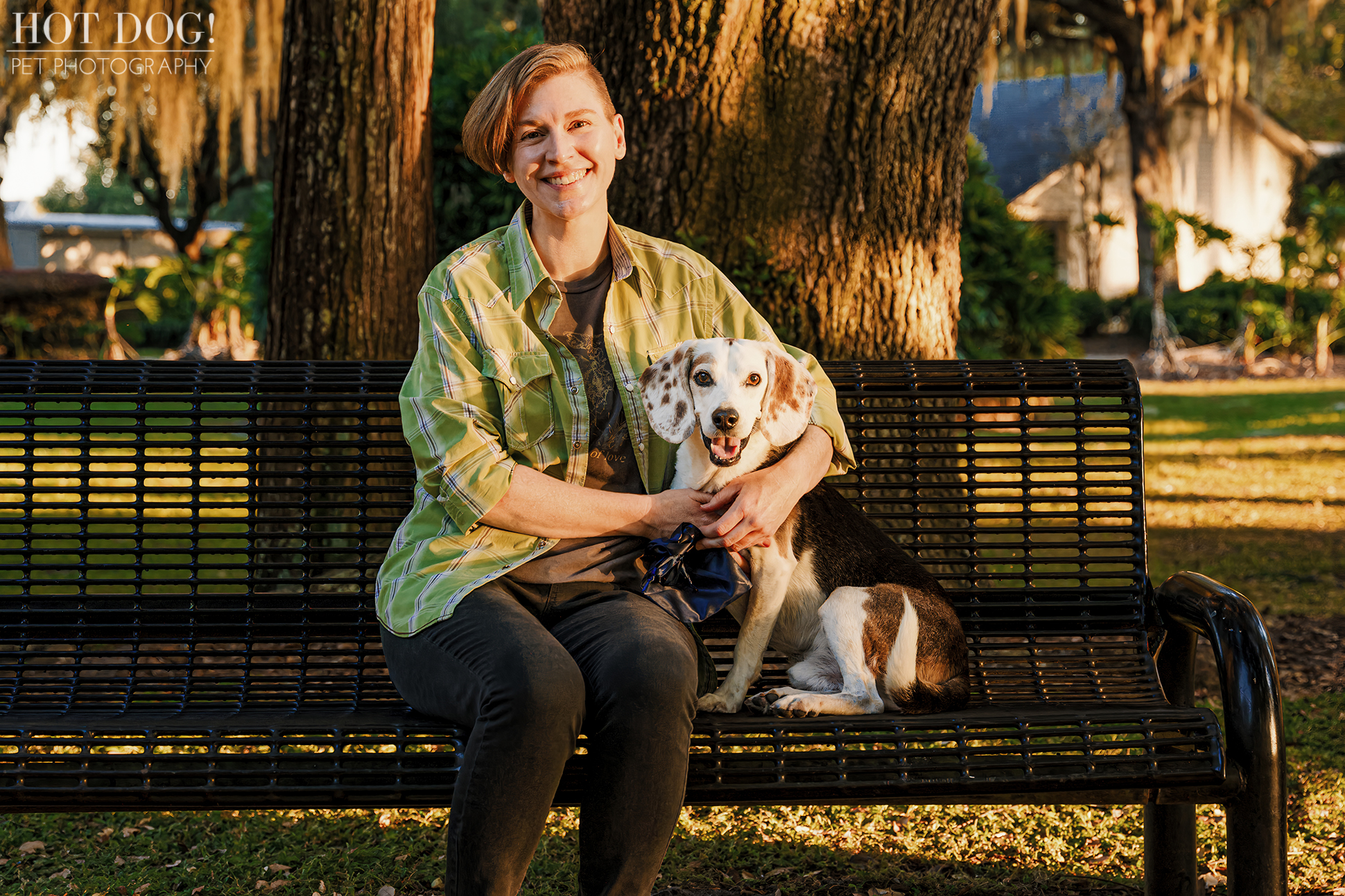 Melanie sitting on a park bench with her tri-color beagle Leonard leaning comfortably against her.