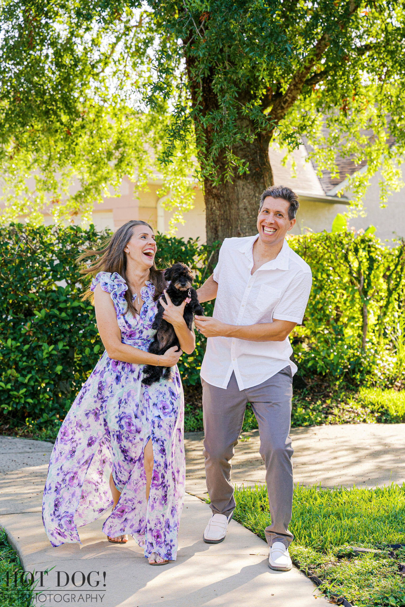 Rae and Nick laughing while walking with Luna during their Apopka pet photography session.