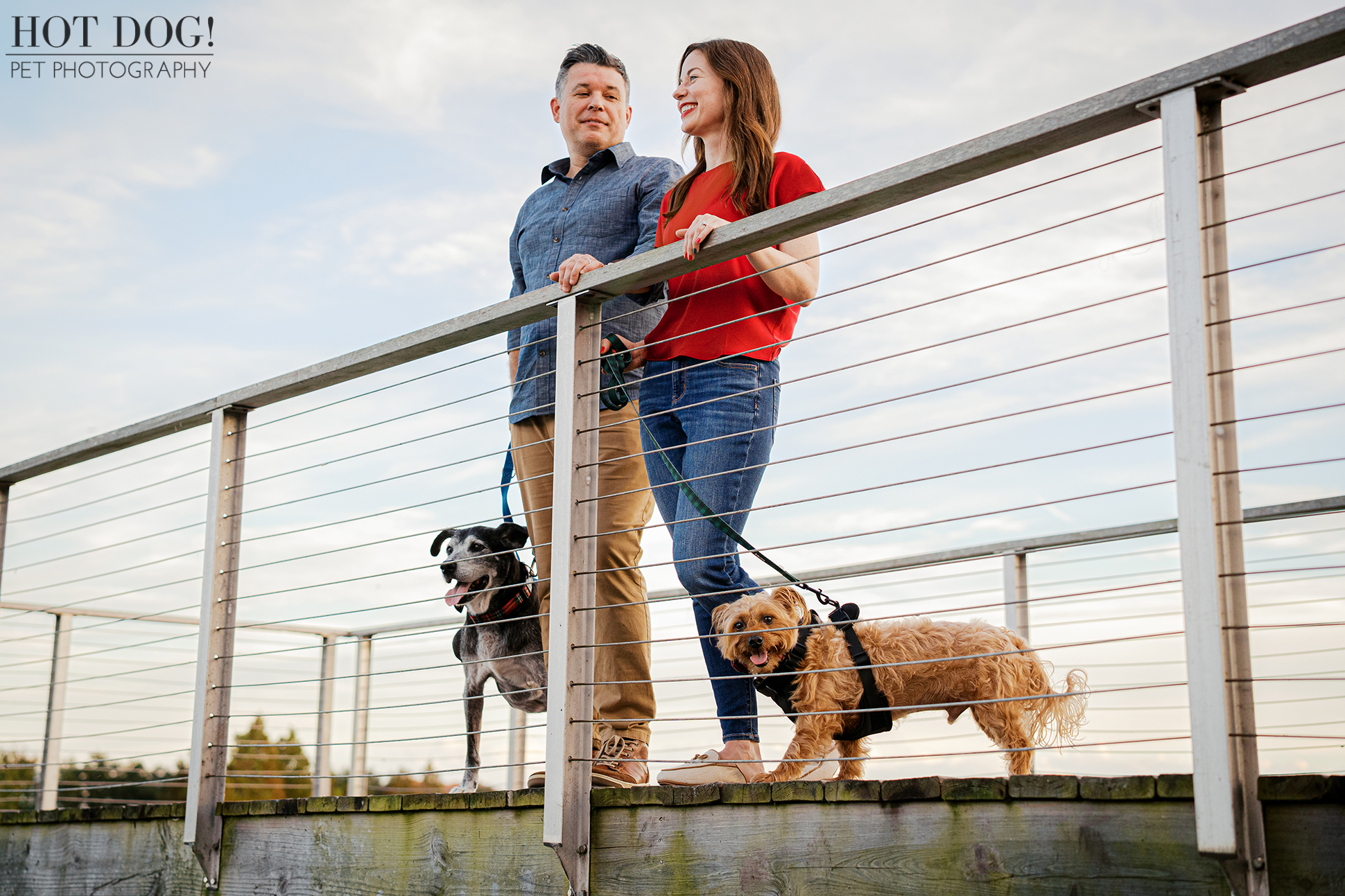 Couple and their dogs posing on a lakeside dock in Laureate Park, Lake Nona, Florida.