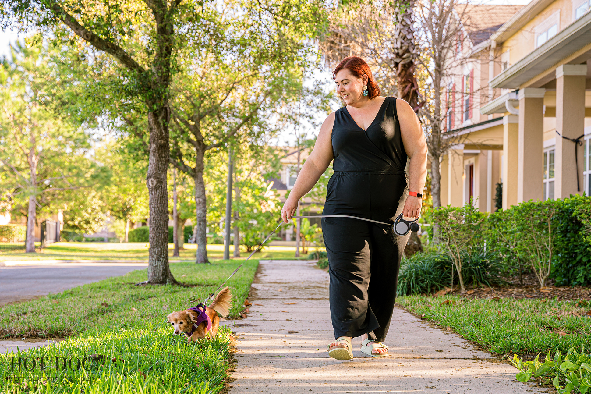 Taya walking Piper the dachshund through a charming tree-lined Lake Nona neighborhood.