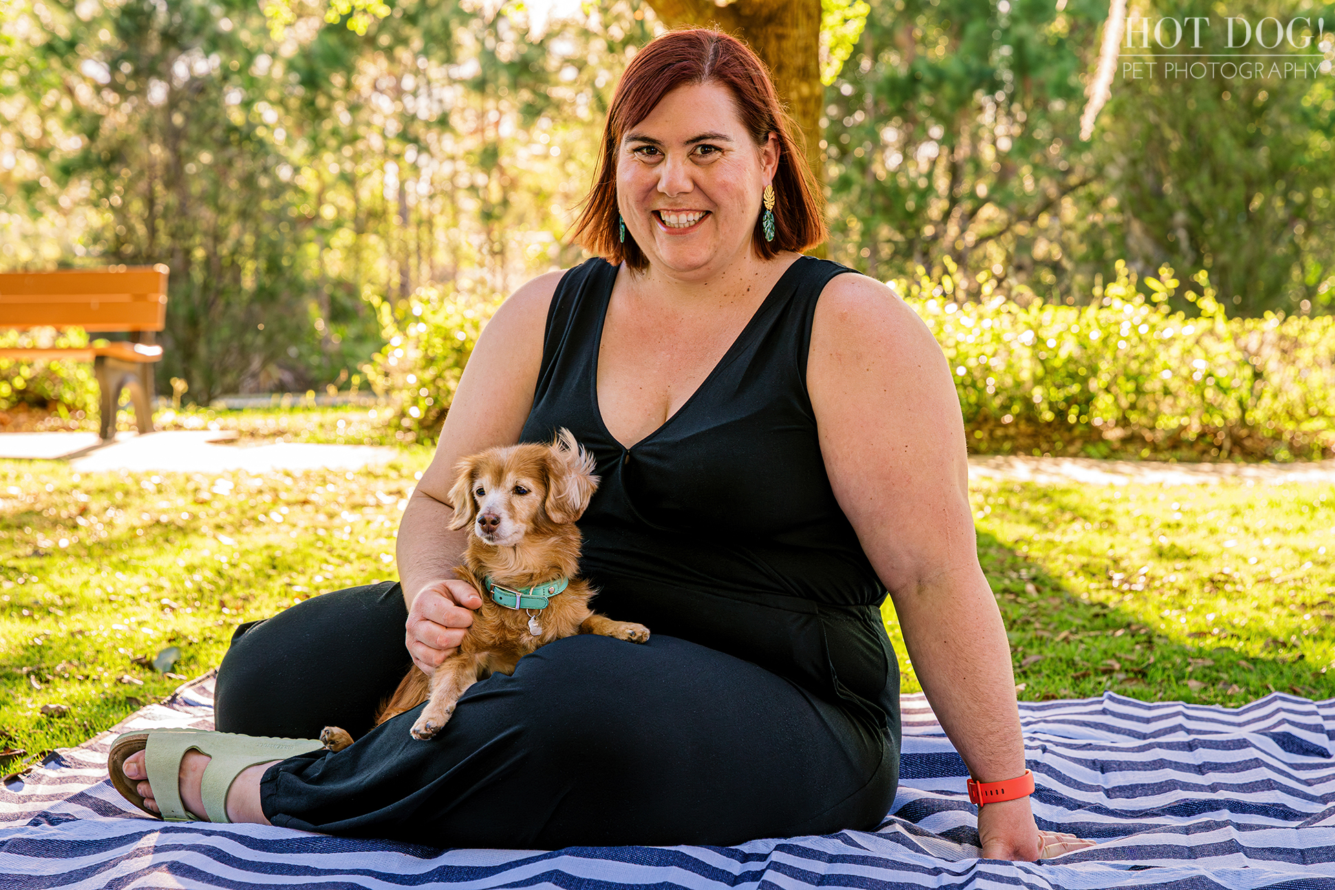 Piper the dachshund mix cuddling on a striped picnic blanket with her mom Taya during a pet photography session in Lake Nona.