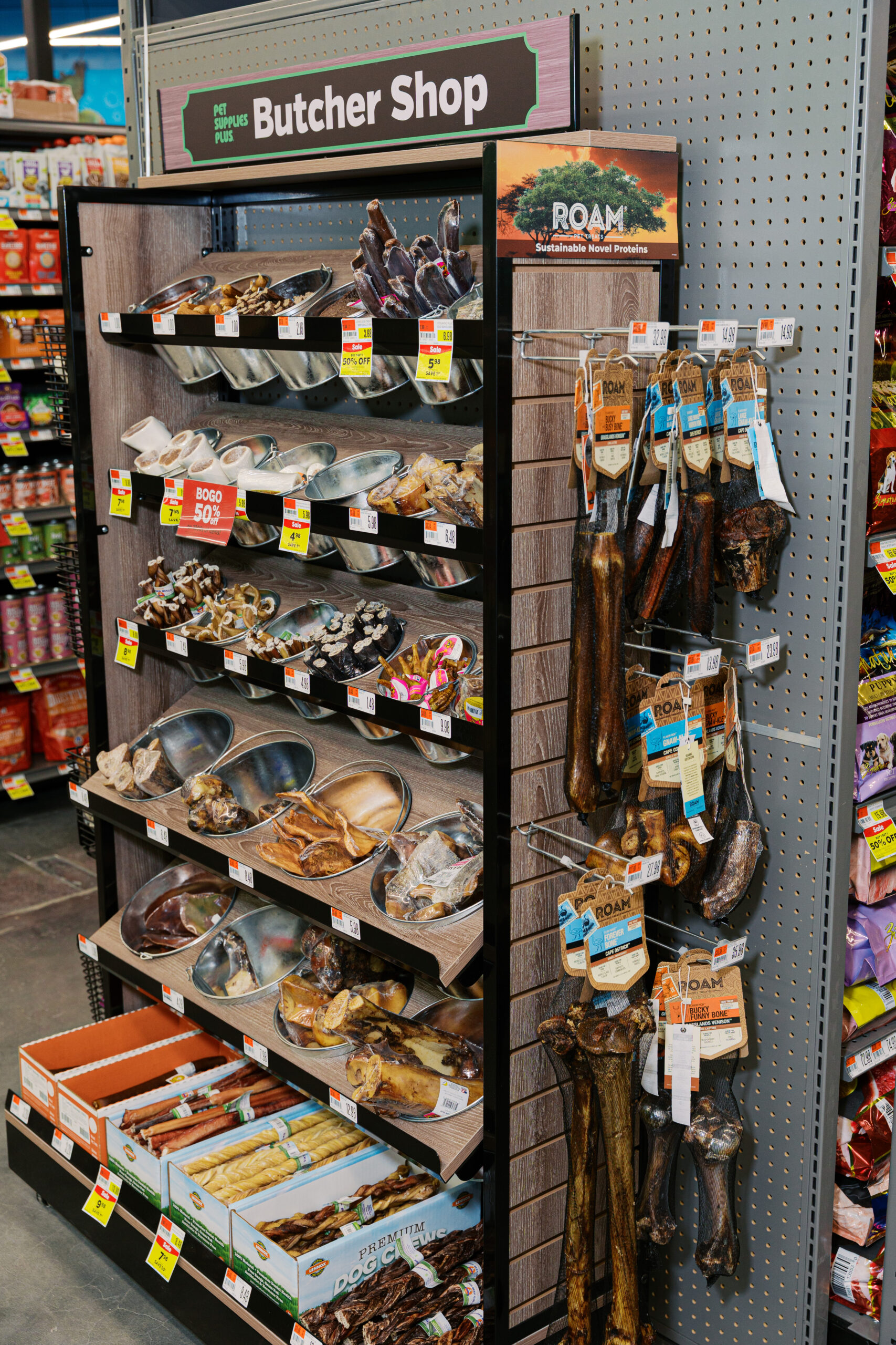 Retail pet store butcher shop display featuring natural dog chews and bones, showcasing product merchandising for pet store photography.