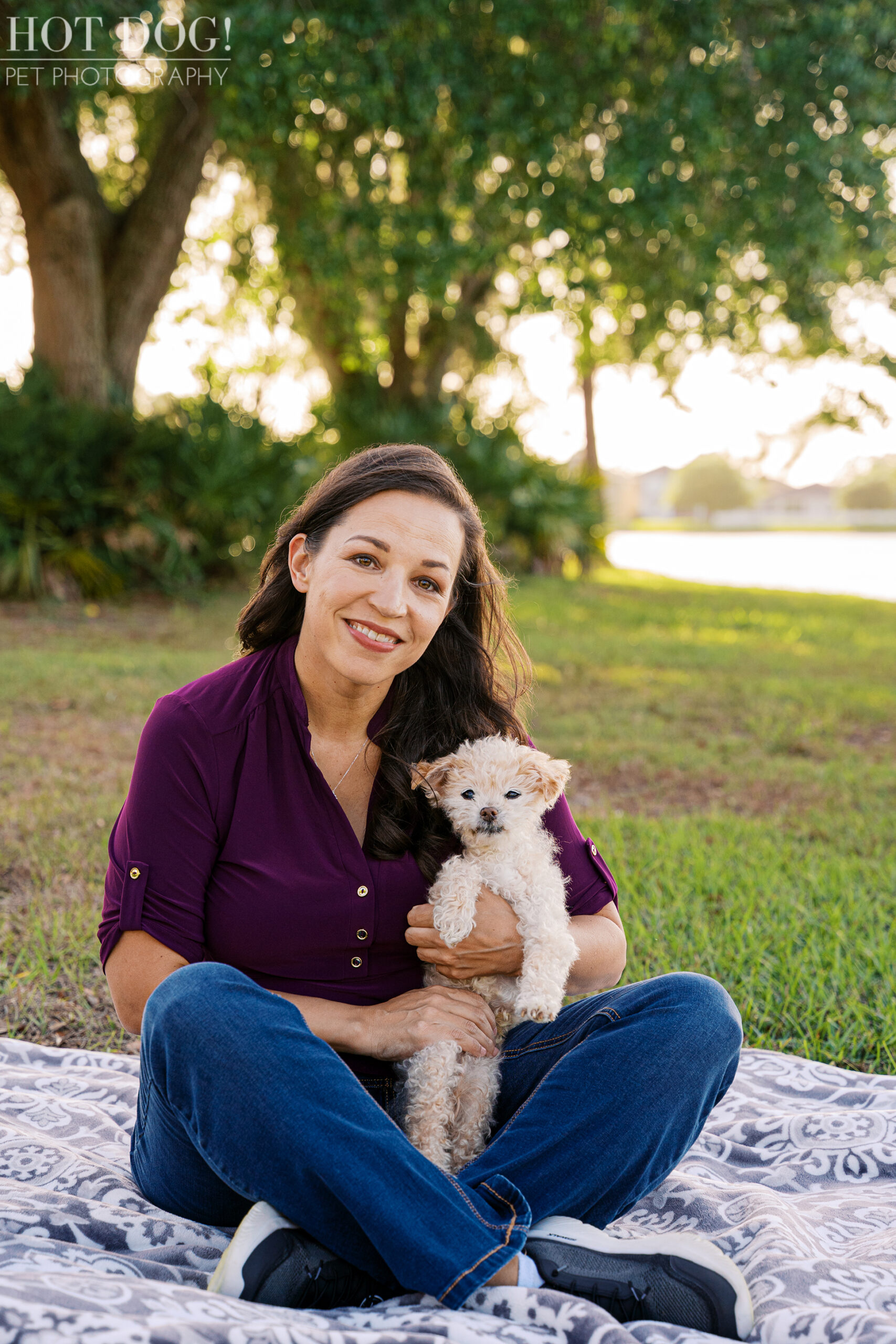 Woman sitting outdoors with her senior cream-colored Jack Russell Terrier during a sunset pet photography session in Orlando.